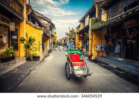 HOI AN, VIETNAM - November 14: local Vietnam man riding a traditional cycle in Hoi An on Apirl 14, 2014. Hoi An, a UNESCO World Heritage site, is a major touristic destination in Central Vietnam.