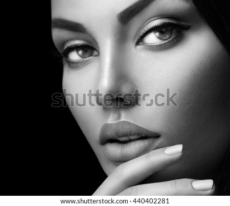 Beauty fashion black and white woman face portrait with perfect makeup and nails isolated on black Beauty fashion black and white woman face portrait with perfect makeup and nails isolated on black