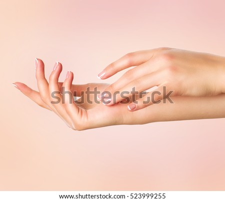 Beautiful Woman Hands. Spa and Manicure concept. Female hands with french manicure. Soft skin, skincare concept. Beauty nails. over beige background