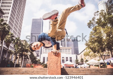 Parkour man doing tricks on the street - Free runner training his acrobatic port outdoors