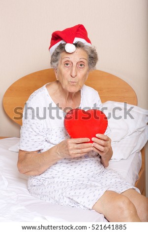 stock-photo-old-woman-old-dressed-in-santa-hat-with-red-heart-in-her-hands-521641885.jpg