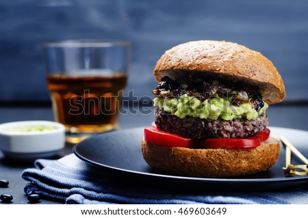 black bean burger with mashed avocado, caramelized onions and tomatoes. toning. selective focus