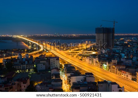 Aerial view of Hanoi cityscape at twilight. Vinh Tuy bridge crossing Red River.