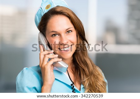 Portrait of a smiling stewardess talking on the phone
