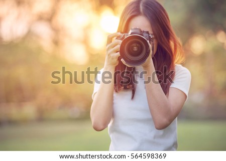 Woman is a professional photographer with dslr camera, outdoor and sunlight, Portrait, copy space.