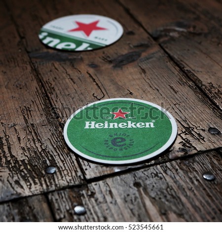 HOLLUM, HOLLAND - AUGUST 4, 2016.: Beer mats from Heineken Lager Beer in vintage background , it was first brewed by Gerard Adriaan Heineken in 1873