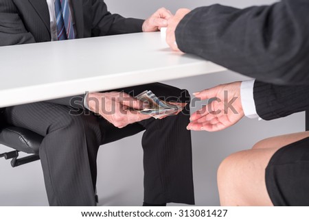 stock-photo-businessman-giving-money-under-a-table-313081427.jpg