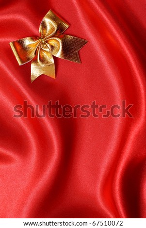 Golden bow on a red silk