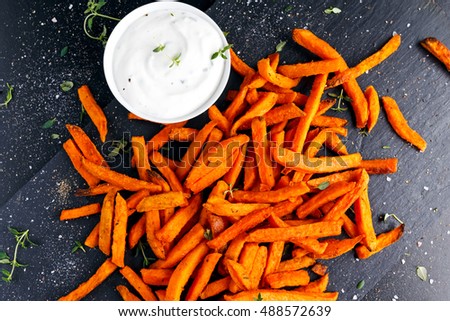 Healthy Homemade Baked Orange Sweet Potato Fries with fresh cream dip souce, herbs, salt and pepper.