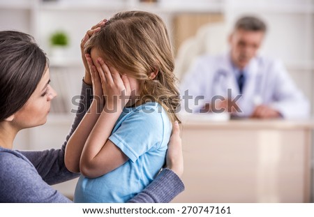 Little girl is crying while with her mother at a doctor on consultation.