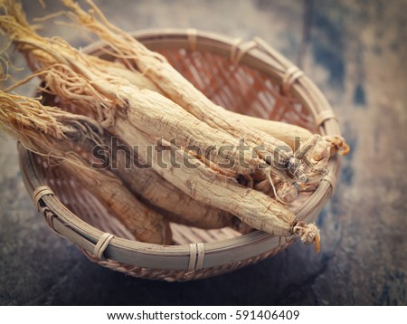 Dry Ginseng Roots on wood background - vintage filter.