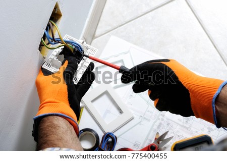 Electrician working safely on switches and sockets of a residential electrical system