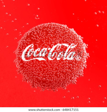 POLTAVA, UKRAINE - APRIL 7, 2017: Coca Cola Cap.Coca Cola Cap in bubbles on a red background.