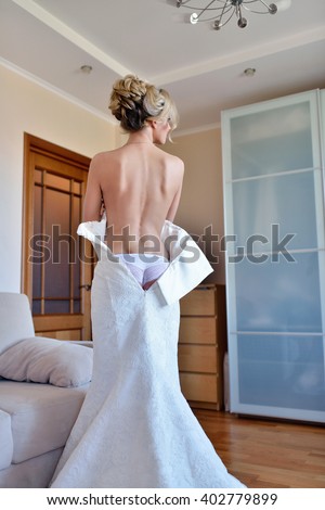 https://thumb7.shutterstock.com/display_pic_with_logo/2302709/402779899/stock-photo-beautiful-bride-in-lingerie-is-wearing-a-wedding-dress-beauty-model-girl-in-white-underwear-402779899.jpg