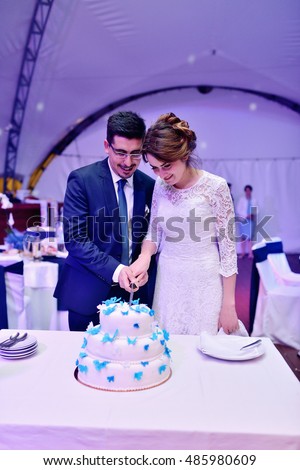 https://thumb7.shutterstock.com/display_pic_with_logo/2302709/485980609/stock-photo-beauty-bride-and-handsome-groom-are-cutting-a-wedding-cake-couple-in-the-restaurant-with-colorful-485980609.jpg