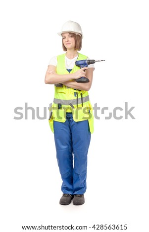 smiling construction female worker in reflective vest and blue workwear holding drill isolated on white background