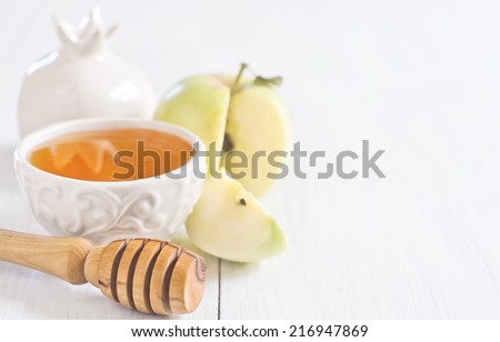 Apple and honey, traditional food of jewish New Year celebration, Rosh Hashana. Selective focus. Copyspace background. High key.