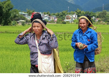 Dien Bien Phu, Vietnam July 31, 2014: Two women Lu ethnic cargo by force of the head.
