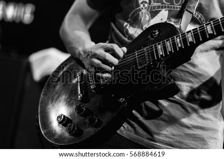 The guitarist is playing guitar , guitar background , music background , black and white guitar