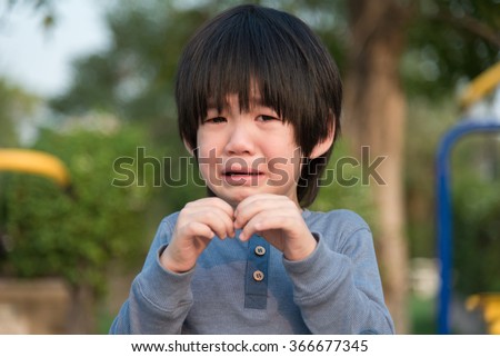 Portrait of asian boy crying in the park
