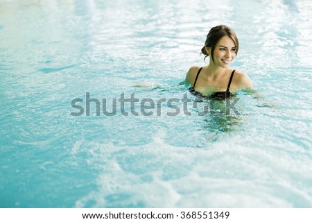 Beautiful young brunette relaxing happily in a swimming pool