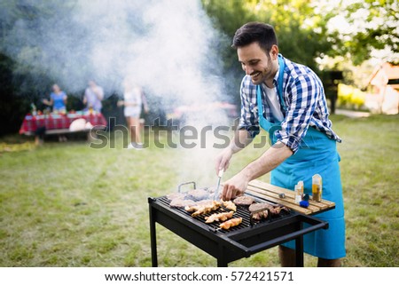 Handsome man preparing barbecue for friends outdoor