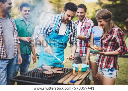 Friends having a barbecue party in nature while having a blast
