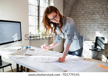 Portrait of young female architect working on project