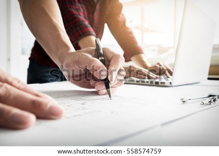 Close-up Of Person's engineer Hand Drawing Plan On Blue Print with architect equipment.