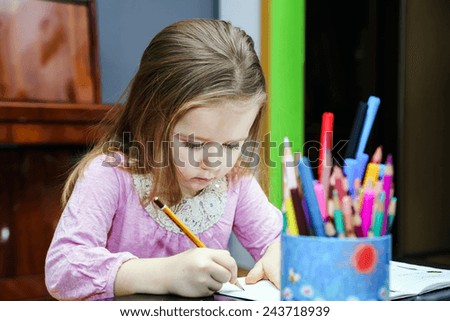 Cute little girl studying to speaking and writing letters at home lesson with her mother