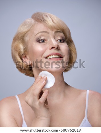 https://thumb7.shutterstock.com/display_pic_with_logo/248251/580962019/stock-photo-beautiful-matured-woman-cleaning-her-face-with-cotton-discs-happy-cheerful-caucasian-toothy-smile-580962019.jpg