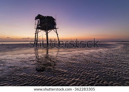 CAN GIO, HO CHI MINH CITY, VIET NAM - JAN 10, 2016: sunrise on the sea with shadow rudimentary leaves home on the Can Gio sea.