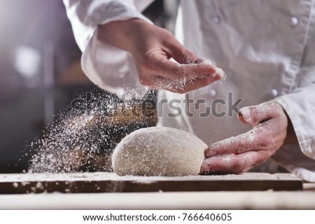 An experienced chef in a professional kitchen prepares the dough with flour to make the bio Italian pasta. the concept of nature, Italy, food, diet and bio.