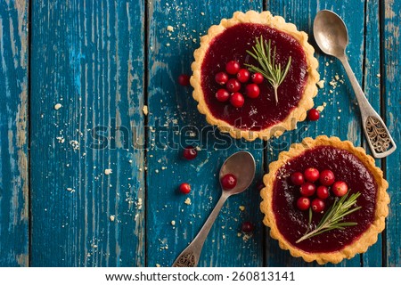 berries jam tarts decorated with cranberry and rosemary, top view