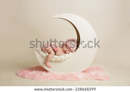 Newborn baby girl sleeping on the moon