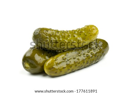 three marinated pickled cucumbers isolated on white