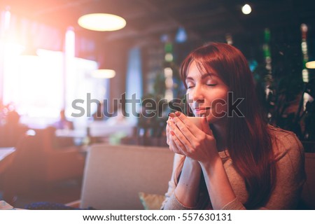 Hot mug of tea with woman hands. beautiful female cup coffee on the restaurnt . Red hair girl