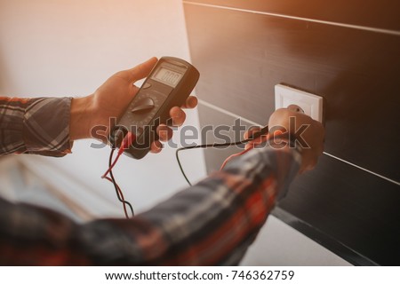 Electrician, Electrician installing new current socket with screwdriver. Installing electrical outlet or socket - closeup on electrician hands
