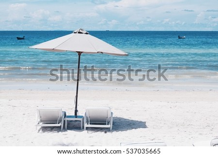 Bai Sao (Star Beach) in Phu Quoc with parasol and two sun bathing chairs on white sandy beach and clear blue water.