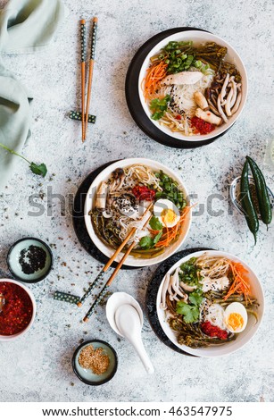 Overhead view of boat noodles in bowl with chopsticks and soup spoon. top view.