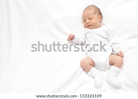 Sleeping baby on back on white bed