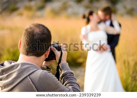 Wedding photographer taking photographs of groom and bride