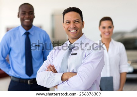 handsome middle aged car salesman with colleagues