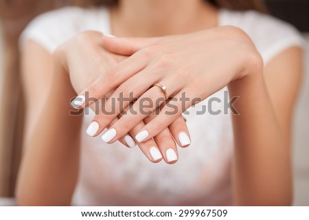 Close up of hands of woman showing the ring with diamond. She is engaged