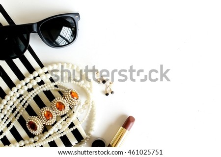 lipstick sunglass pearl necklace fabric on white background