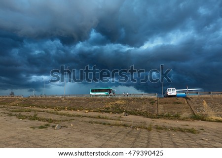 Quy Nhon City, Binh Dinh Province, Vietnam - August 27, 2016: Images buses parked to await tourists at the same time a storm with dark clouds are pulling ahead. danger and impressive