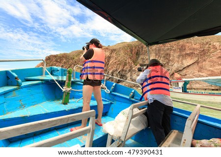 Quy Nhon City, Binh Dinh Province, Vietnam - August 28, 2016: tourists are trying to take a picture on wooden boat traveling KyCo Island, Binh Dinh Province, Vietnam