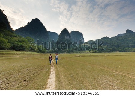Nam Cha, Cao Bang province, Vietnam - September 22, 2016 : Two young girls traveling to explore wilderness lake Nam Cha. Scene here is spectacular with huge limestone mountains of Cao Bang, Vietnam