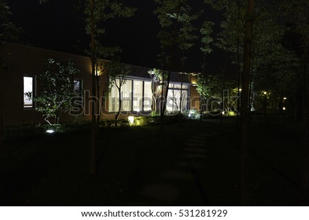 Flamingo Dai Lai, Vinh Phuc province, Vietnam - October 11, 2016 : beautiful living room of a villa overlooking the garden at night with the rocks on the grass at Flamingo Dai Lai resort