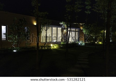 Flamingo Dai Lai, Vinh Phuc province, Vietnam - October 11, 2016 : beautiful living room of a villa overlooking the garden at night with the rocks on the grass at Flamingo Dai Lai resort